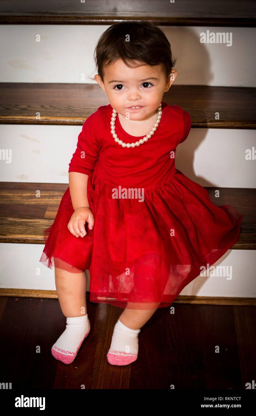 Fille, 1 ans et demi en robe rouge avec collier de perles Photo Stock -  Alamy