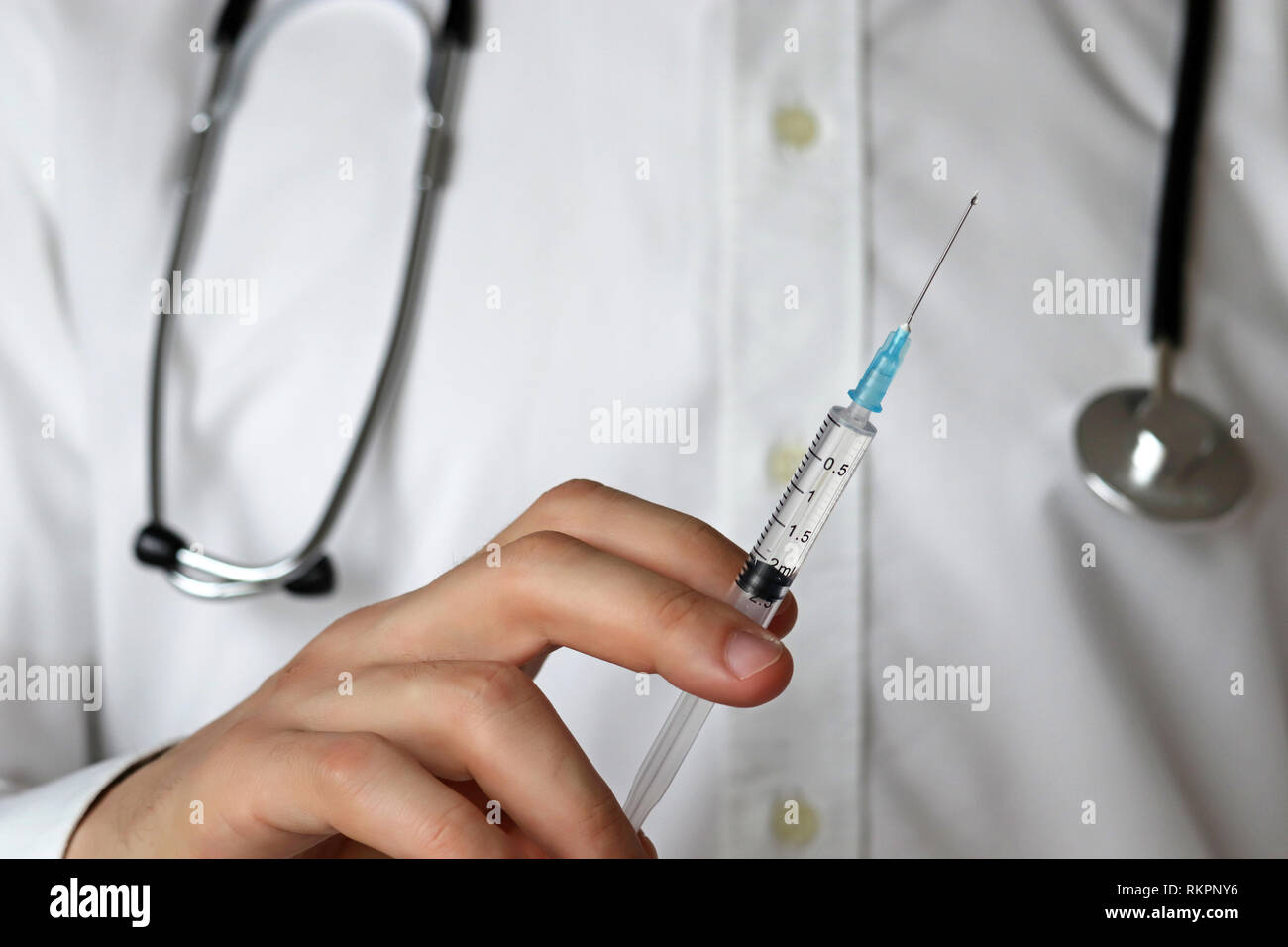 Médecin avec une seringue, l'homme dans un manteau blanc avec stéthoscope prépare à l'injection. Concept de la vaccination, de traitement en clinique, chirurgie plastique Banque D'Images