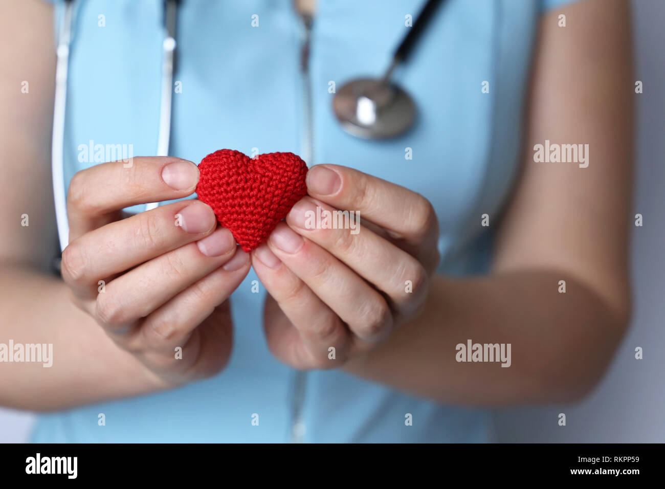 Soins de santé, cardiologie, femme médecin stéthoscope avec coeur en tricot rouge tenue en mains. Concept de cardiologue, le don de sang, de charité, de traitement Banque D'Images