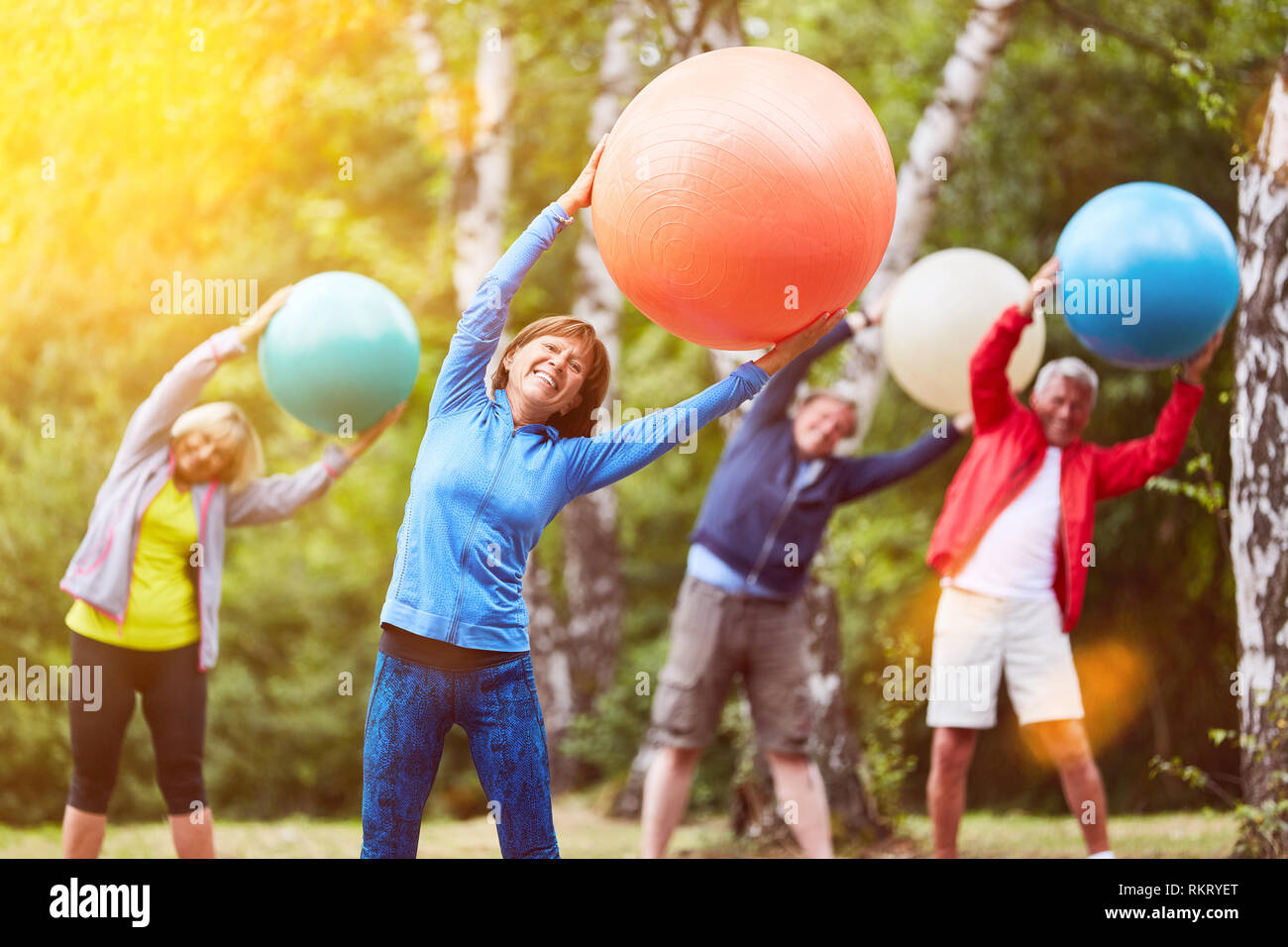 Groupe d'aînés de retour avec ballon de gymnastique de formation dans la nature Banque D'Images