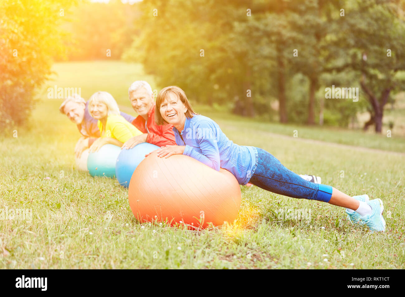 La gymnastique senior avec ballon de gymnastique dans la nature en tant que formation retour Banque D'Images