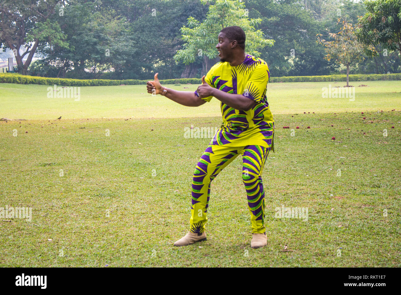 Un homme africain dans un champ d'herbe verte et un ciel clair présente imaginaires ou service. Banque D'Images