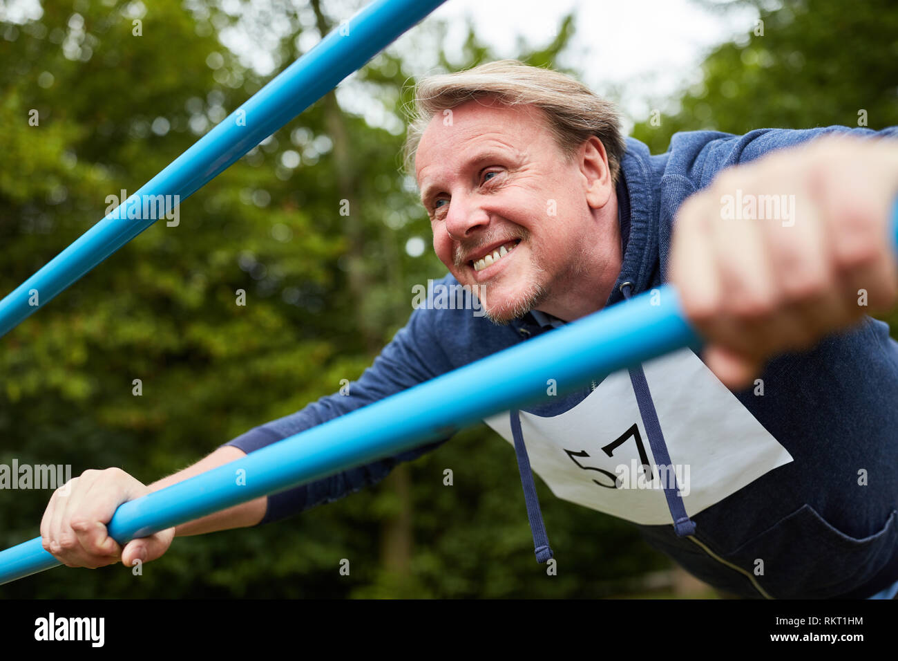 Man push-up faire un exercice sur l'équipement de sport sur le chemin vous garniture Banque D'Images
