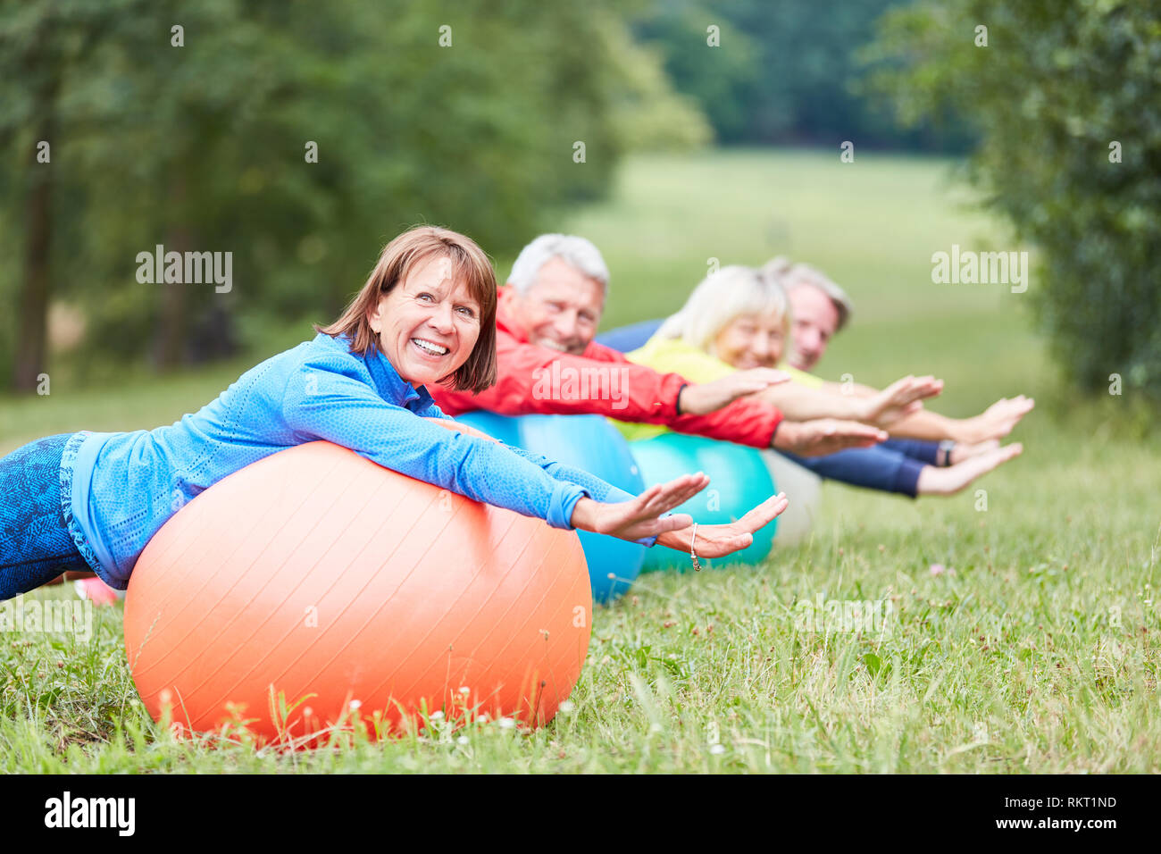 Groupe principal à l'arrière de la formation avec ballon de gymnastique dans une classe de réadaptation Banque D'Images