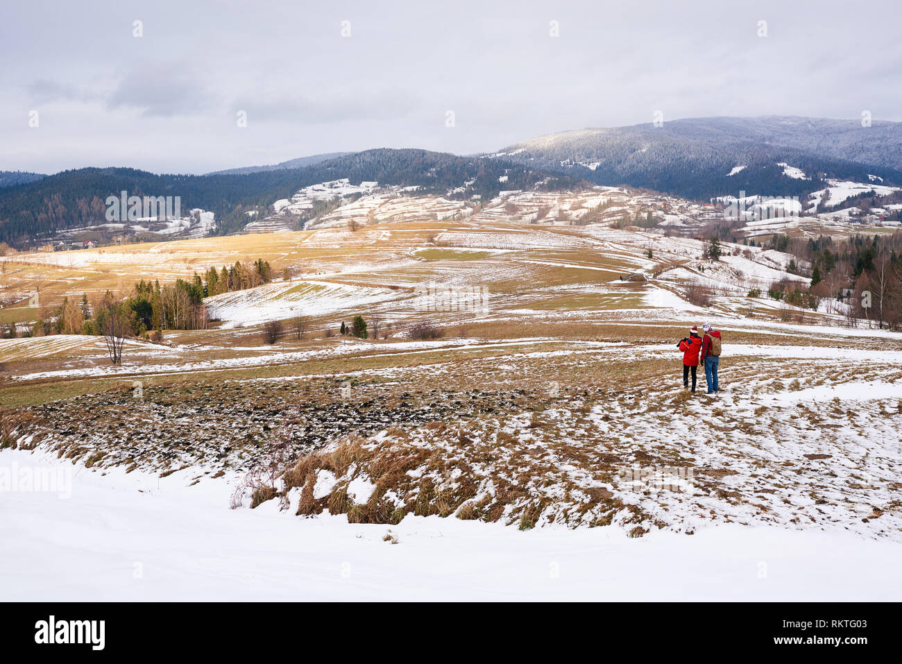 Équipement de randonnée en couple debout ensemble dans un champ couvert de neige tandis que dehors pour une promenade dans l'hiver Banque D'Images