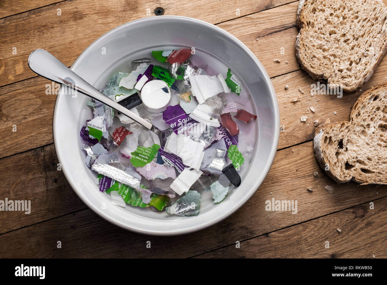 Un bol de soupe composée de déchets plastiques avec du pain. Banque D'Images