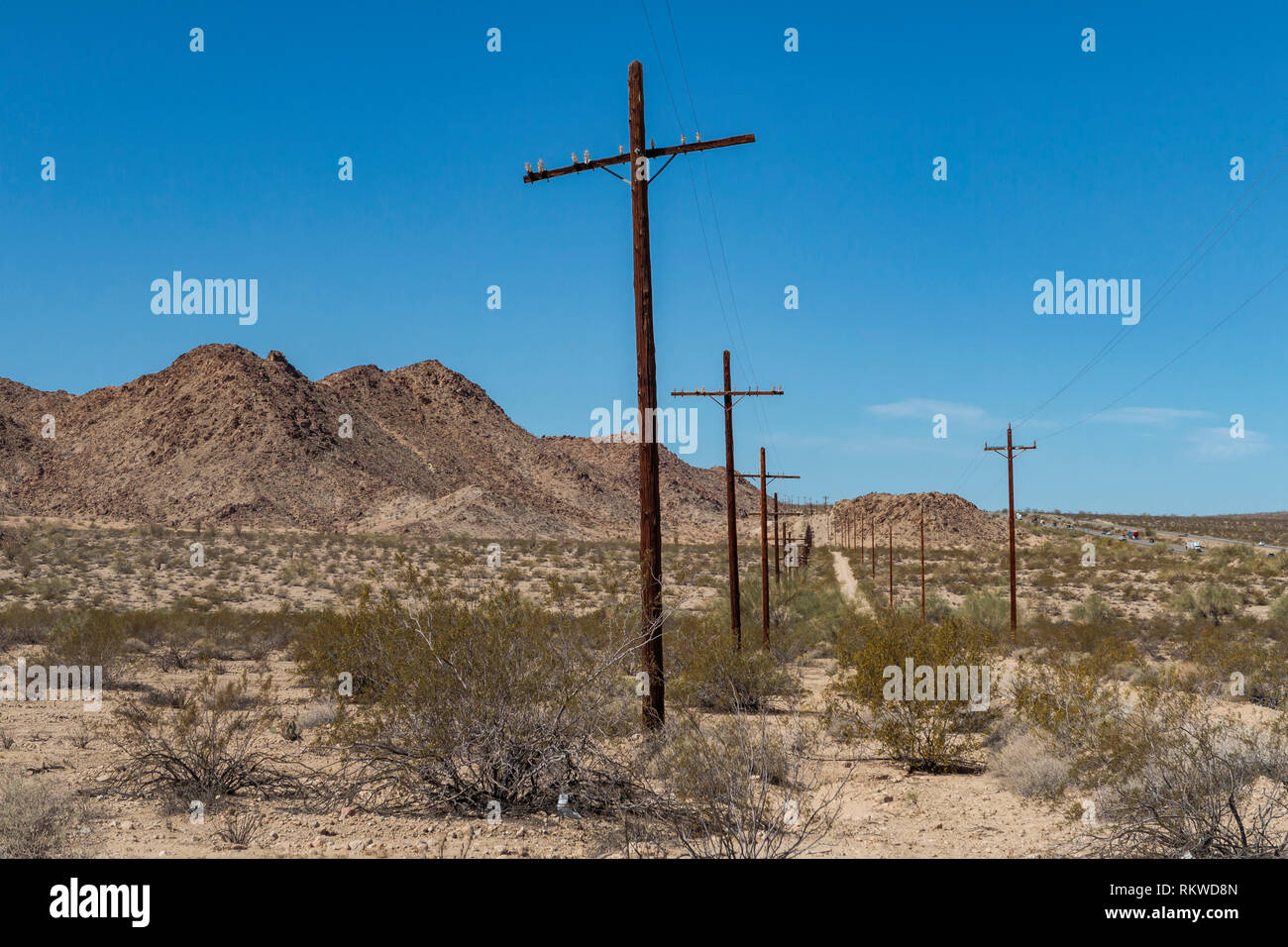 Vieux chemin désaffecté sur la frontière de la Californie et l'Arizona bordée de poteaux télégraphiques. Banque D'Images