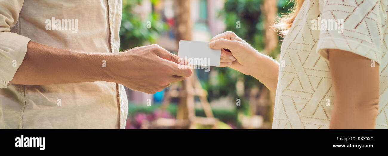 Une femme donne à un homme carte clé de sécurité ou une carte de format long bannière Banque D'Images