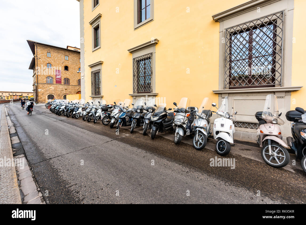 Florence, Italie - 31 août 2018 : Firenze orange jaune de bâtiments par Arno en été nuageux matin en Toscane avec des motos garées Banque D'Images