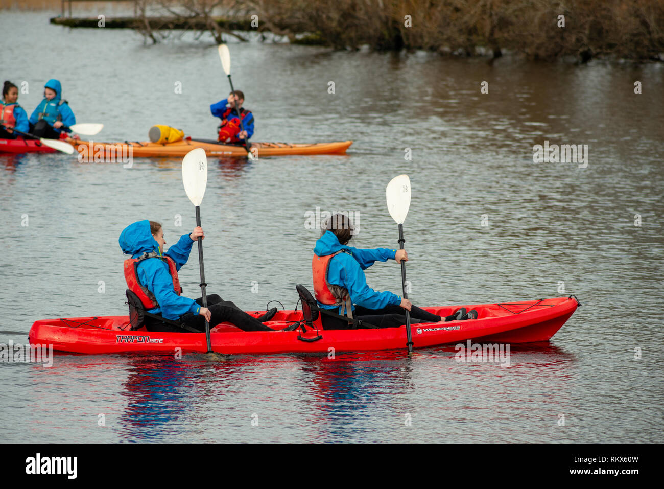 Groupe d'adolescents jeunes filles et un instructeur appréciant le canoë kayak pagayer sur le lac Lough Leane dans le parc national de Killarney, comté de Kerry, Irlande Banque D'Images