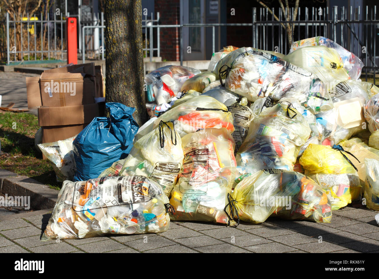 Les sacs jaunes pour les déchets plastiques, allongé sur le trottoir, Brême, Allemagne I Gelbe Zertifikat für Plastikmüll, auf dem Bordstein liegend, Brême, Allemagne I Banque D'Images