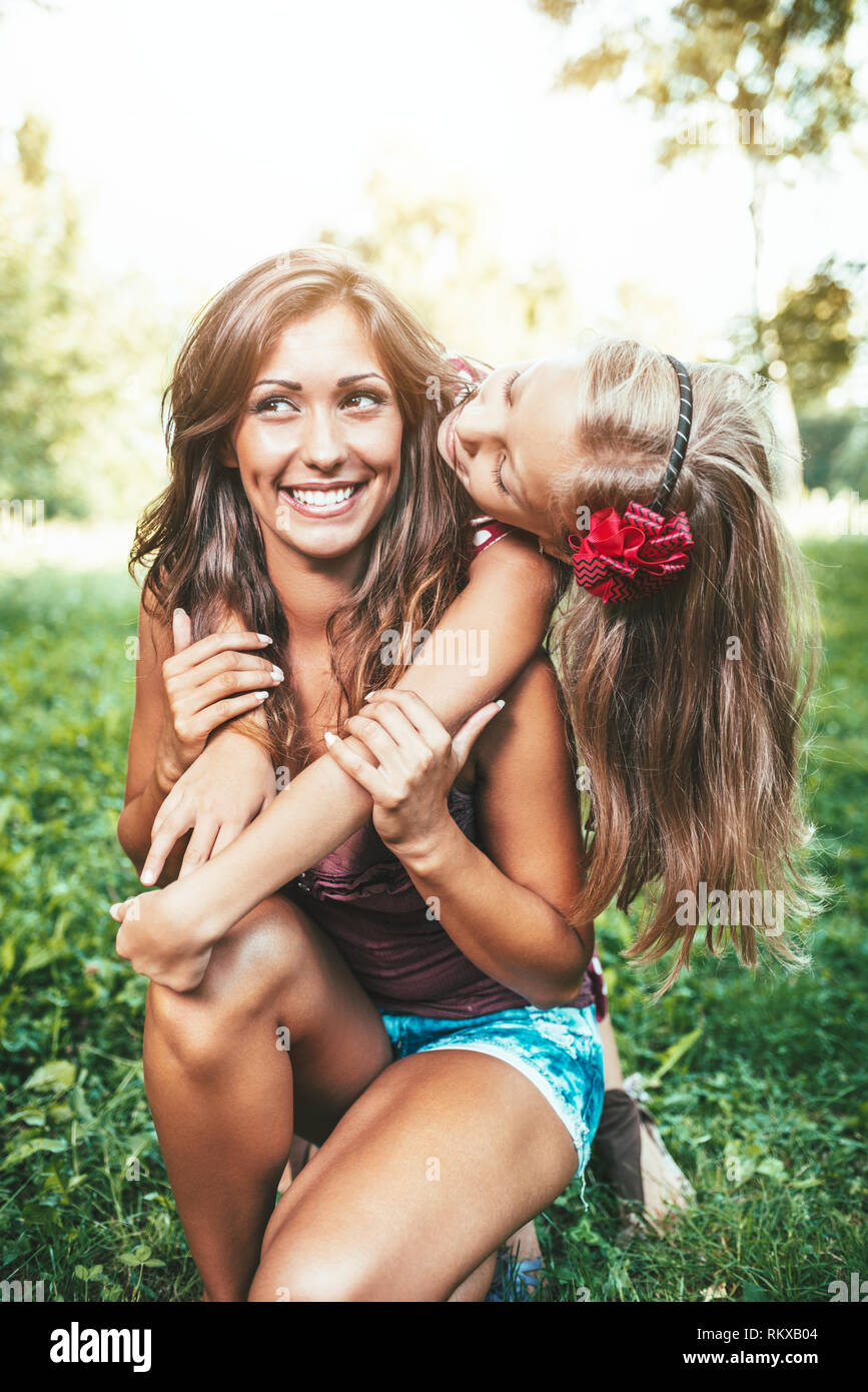 Belle Mère et fille s'amuser au parc au printemps accolades et embrassades. Banque D'Images