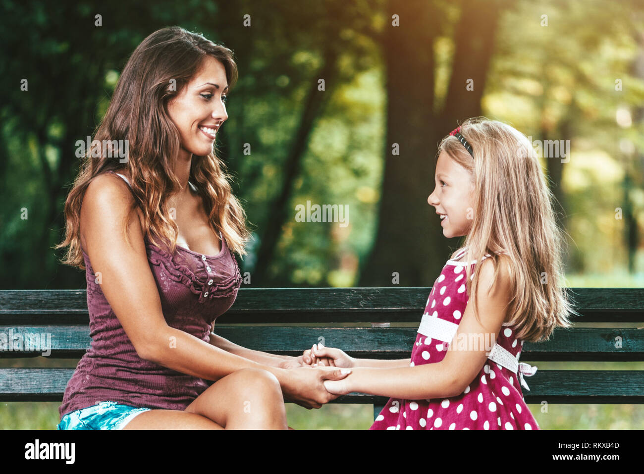 Belle Mère et fille s'amusent au parc au printemps, se tenant la main les uns les autres. Banque D'Images