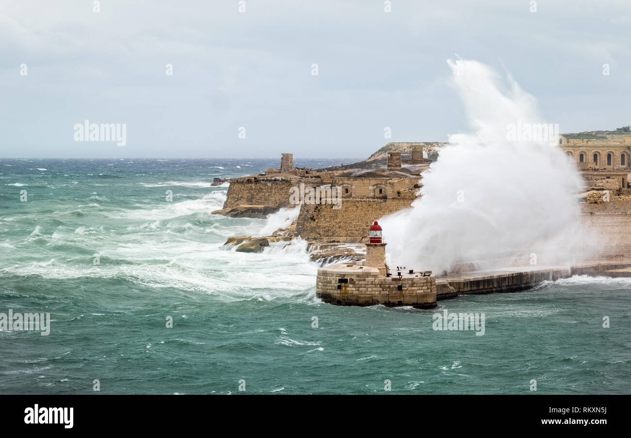 Brise-lames Est Ricasoli et phare de résister à la mer de matières premières et de hautes vagues. Fort Ricasoli, Kalkara, Malte, l'Europe. Banque D'Images