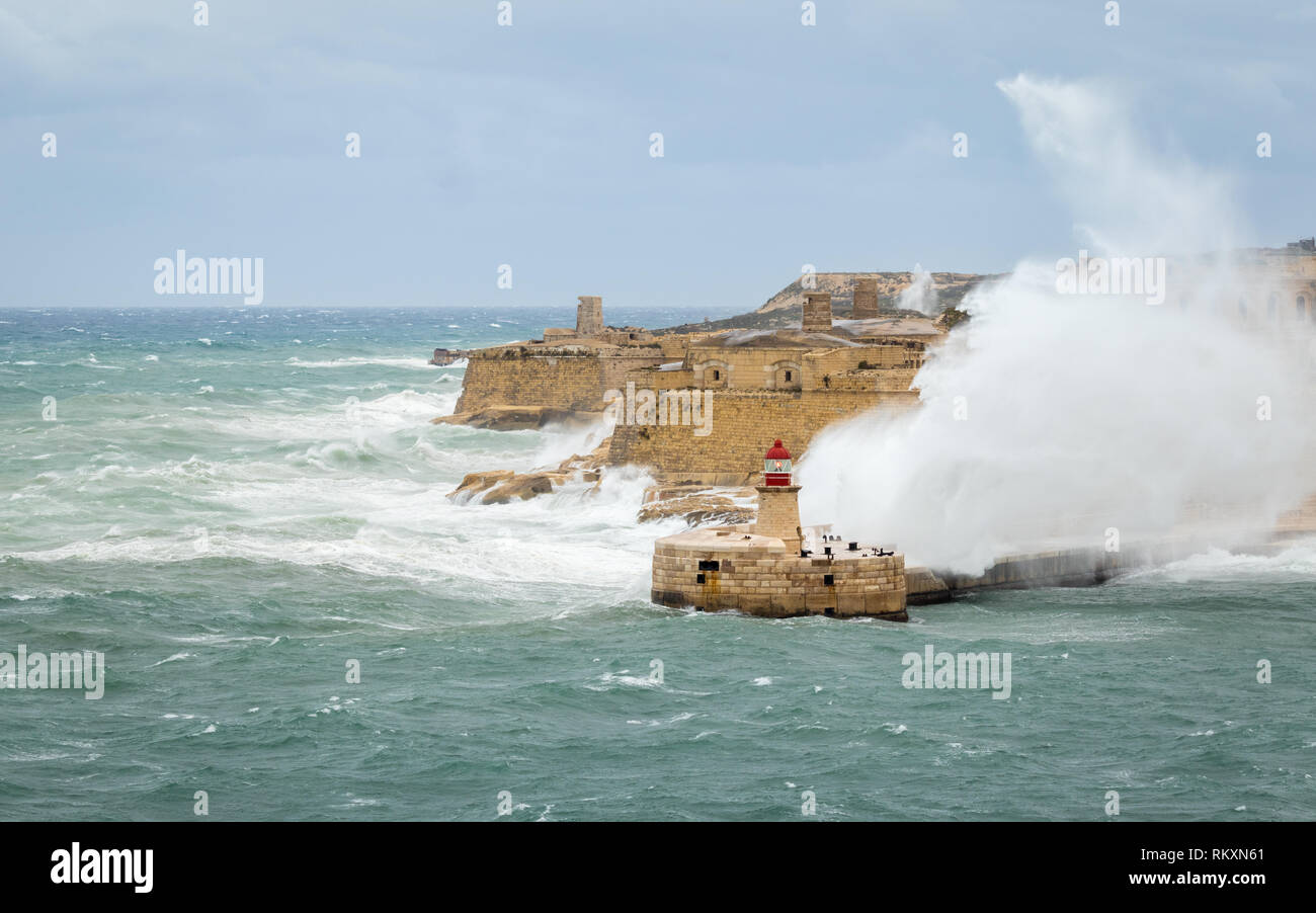 Brise-lames Est Ricasoli et phare de résister à la mer de matières premières et de hautes vagues. Fort Ricasoli, Kalkara, Malte, l'Europe. Banque D'Images