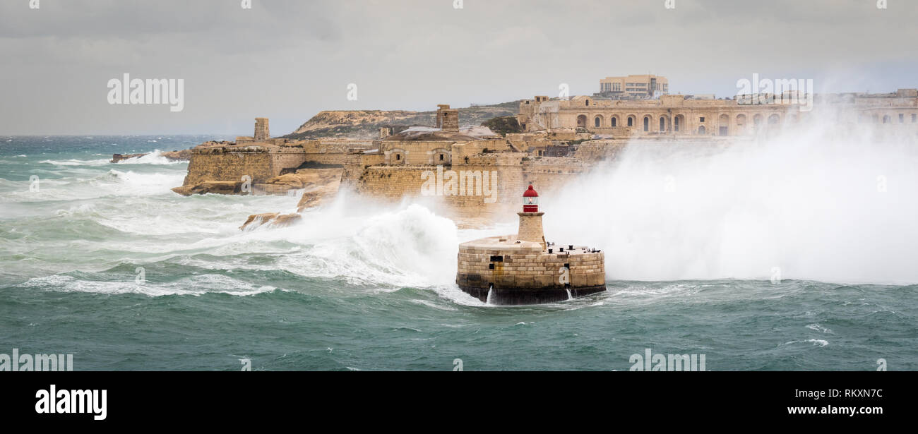 Brise-lames Est Ricasoli et phare de résister à la mer de matières premières et de hautes vagues. Fort Ricasoli, Kalkara, Malte, l'Europe. Banque D'Images
