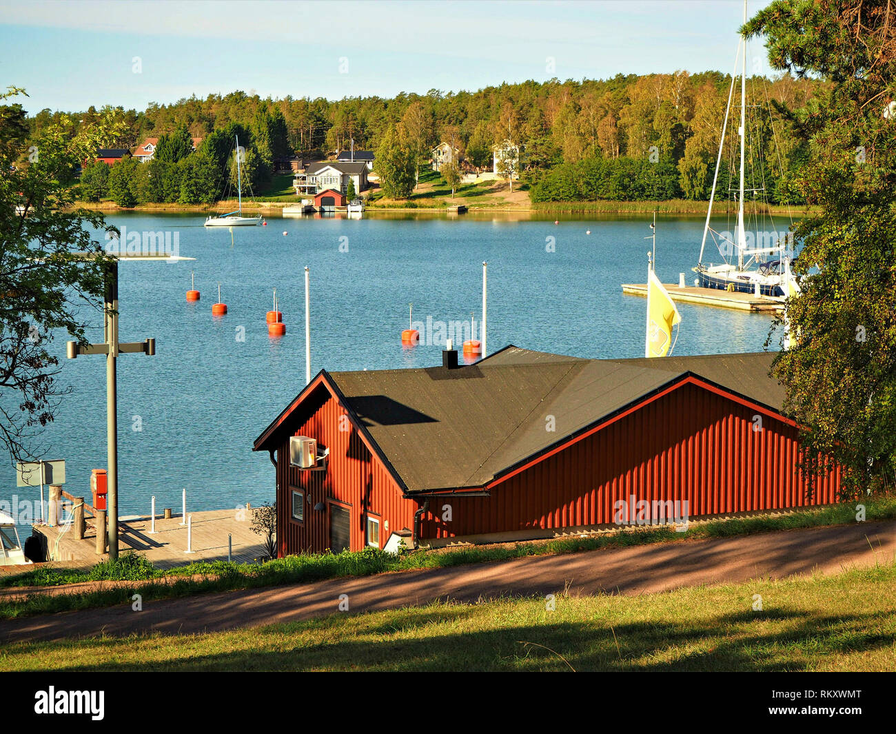 Vue sur un canal de la Mer Baltique avec des bateaux à voile de la côte à Mariehamn, Finlande Aland en bois avec, à feuillage d'automne et d'élégantes maisons Banque D'Images