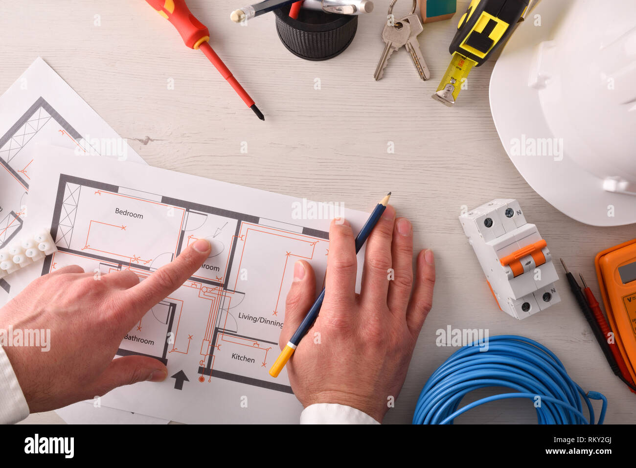 Ingénieur technique de l'électricité en pointant dans un schéma électrique de l'habitation l'installation sur le bureau avec des outils autour. Composition horizontale. Haut Banque D'Images