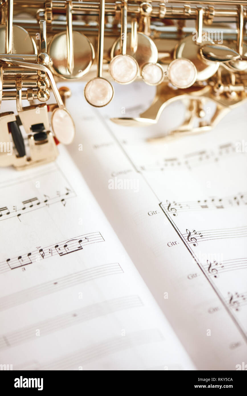 Close up vertical de l'image des touches de saxophone allongé sur le notes de musique. Instruments de musique. Banque D'Images