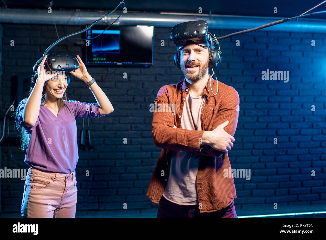 Homme heureux gagner jeu de réalité virtuelle avec Jeune femme debout dans la salle de jeu Banque D'Images