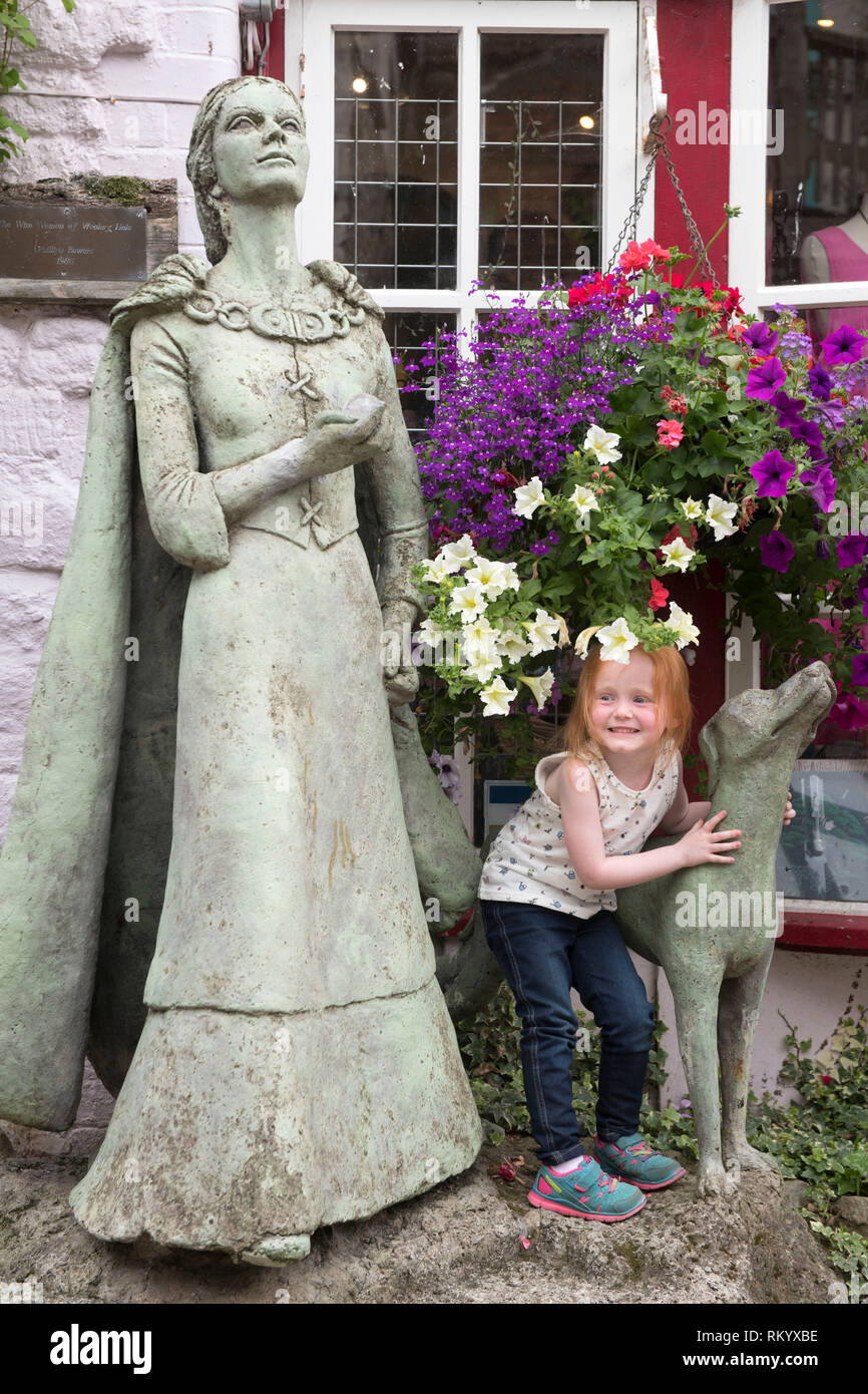 Enfant avec la statue de la femme sage de Wookey Hole à Glastonbury, Royaume-Uni (par artiste Phillipa Bowers) Banque D'Images