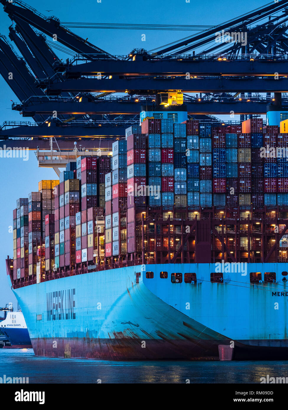 Commerce international - des conteneurs de transport d'être chargés et déchargés d'un navire porte-conteneurs Maersk dans le port de Felixstowe Royaume-uni. Banque D'Images