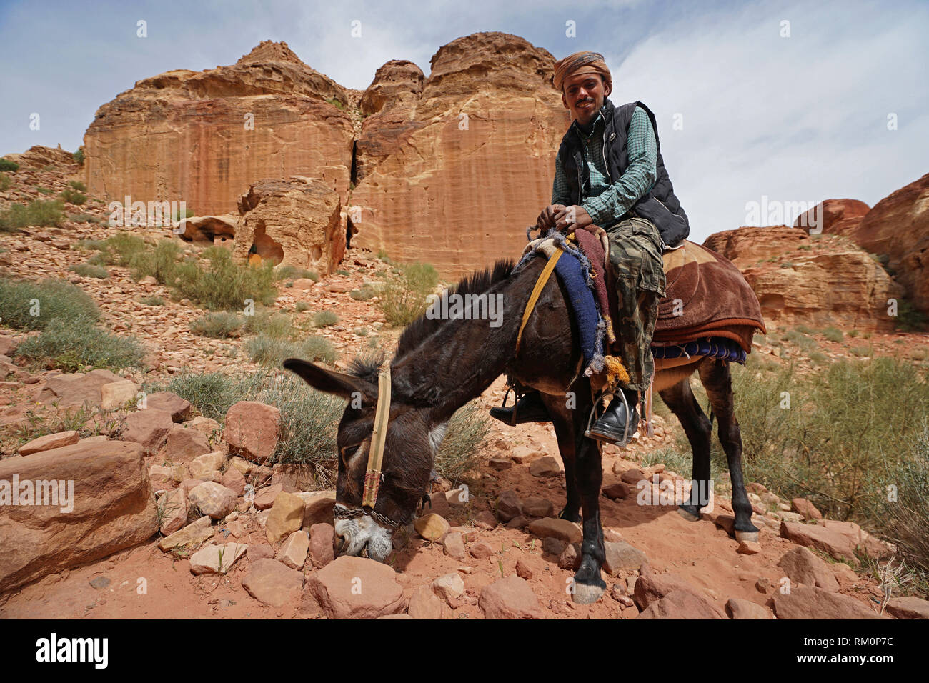 Un Bédouin amical sur un mulet témoigne de l'hospitalité locale à Petra en Jordanie. Banque D'Images