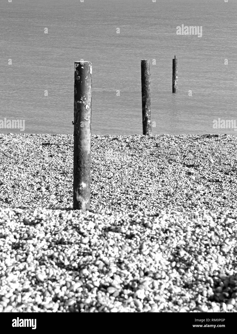 De pieux d'acier rouillé menant de la plage de galets de la mer à la baie de Sandwich, Kent, UK. Banque D'Images