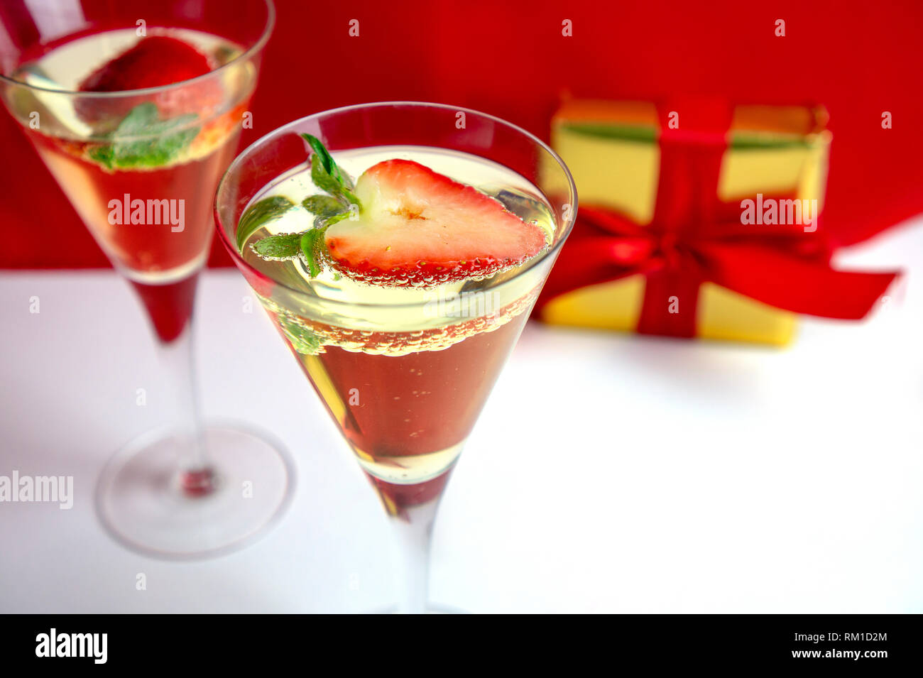 Deux verres de champagne avec des fraises en forme de coeur et un cadeau à l'arrière-plan la Saint-valentin concept Banque D'Images