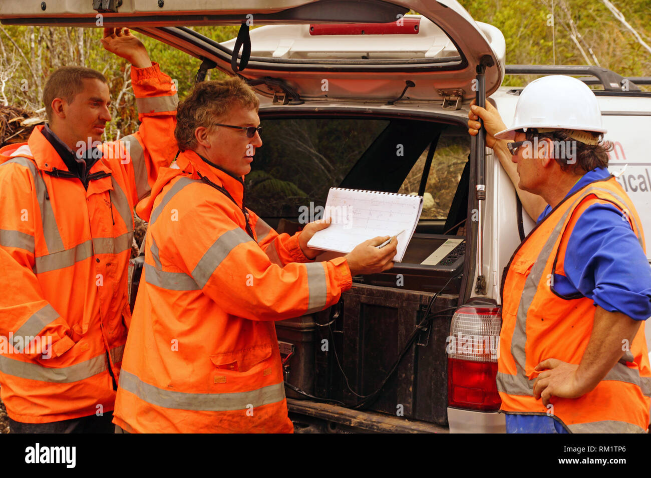 Les géologues dans le domaine de discuter des résultats d'un sondage sismique réflexion Banque D'Images