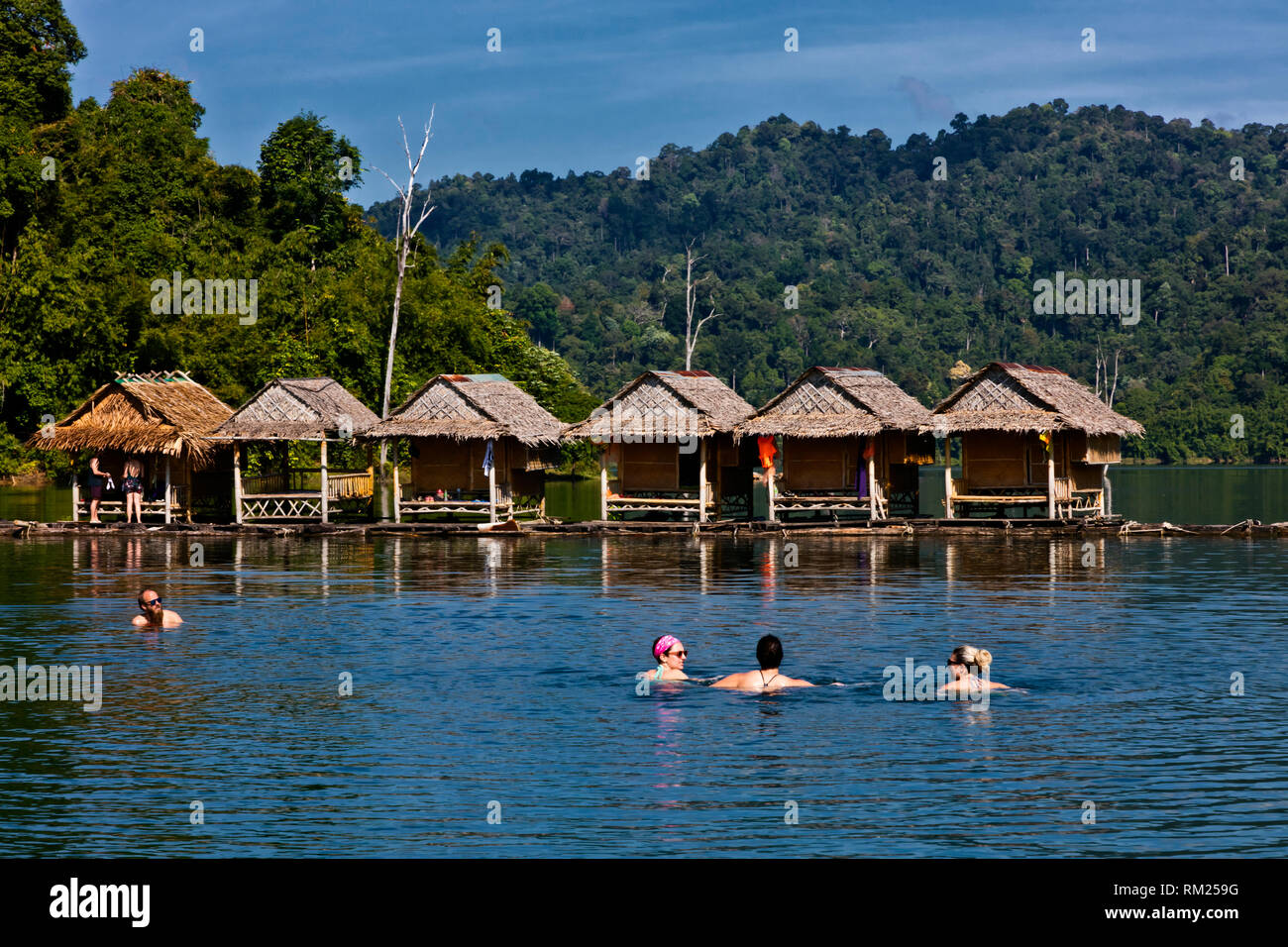 Baignade dans les eaux chaudes près de l'un des 22 bungalows flottants sur le lac CHEOW LAN dans le parc national de Khao Sok - Thaïlande Banque D'Images