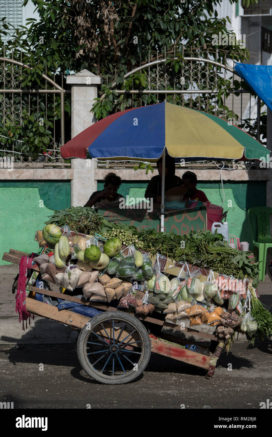 Vendeur de nourriture, avec parapluie coloré, Dili, Timor oriental Banque D'Images