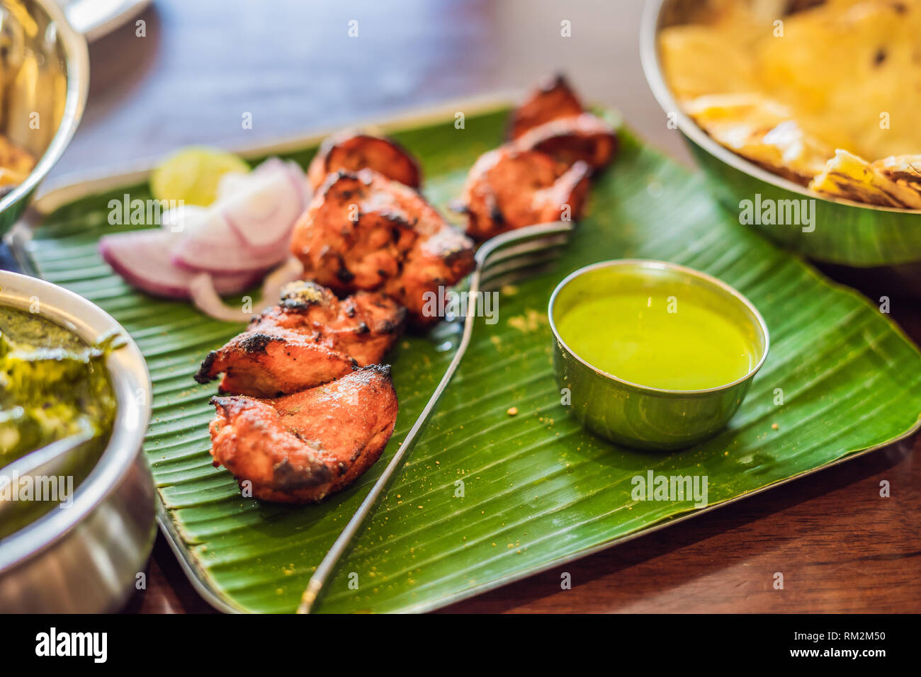 Un assortiment de nourriture indienne sur fond de bois sombre. Plats et apéritifs de la cuisine indienne. Curry de poulet, beurre, riz, lentilles, paneer, samosa, naan Banque D'Images