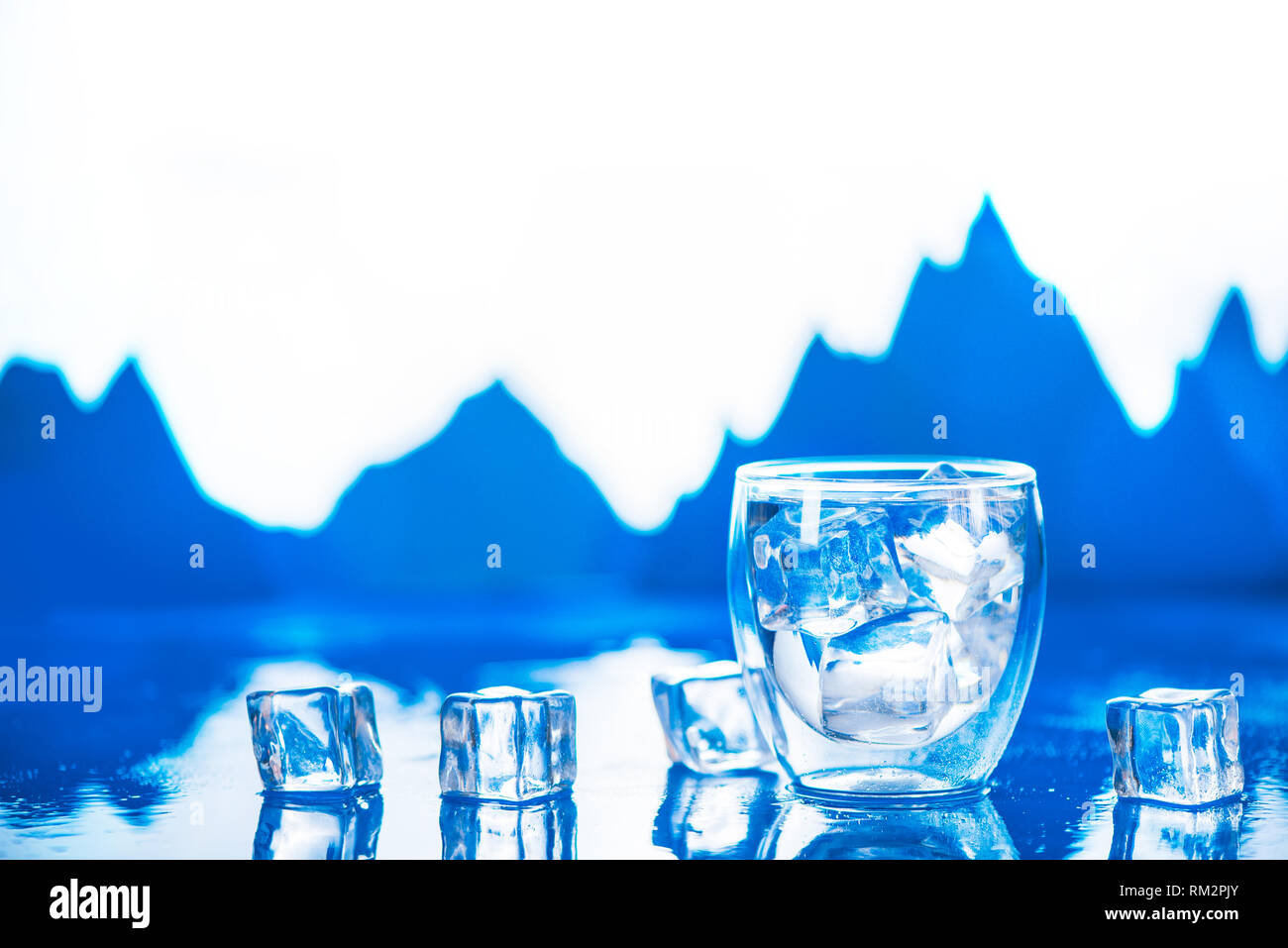 Verre double paroi d'eau claire sur un fond froid avec des glaçons et des pics de montagne. L'eau douce potable concept avec copie espace. Banque D'Images