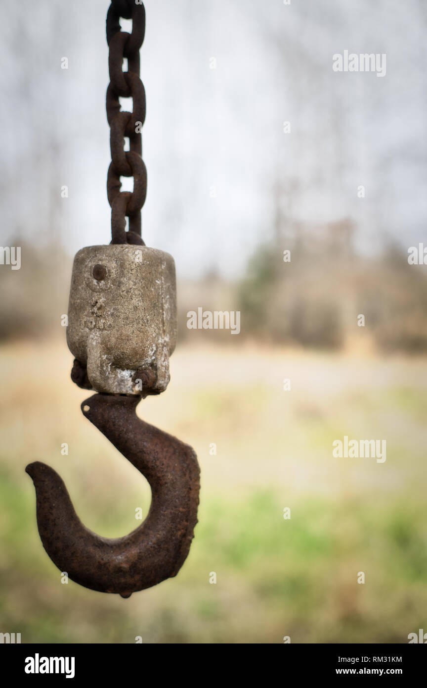 Un vieux Treuil à chaîne rouillée pend du chevron d'un bâtiment abandonné dans les régions rurales de l'Alabama. Banque D'Images