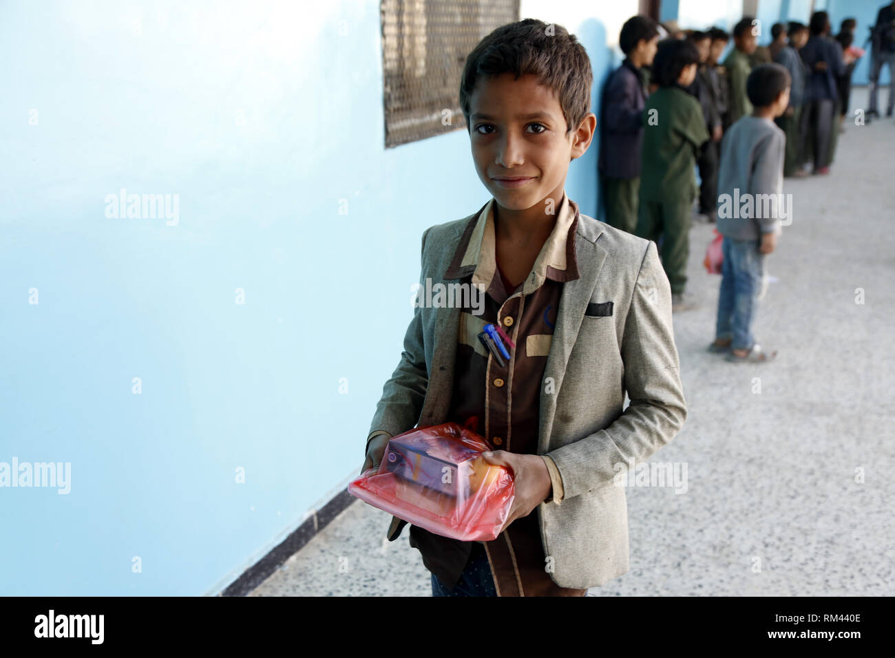 Sanaa, Yémen. Feb 13, 2019. Un étudiant de conflit yéménite tient le petit-déjeuner à l'aide d'une école à Sanaa, Yémen, le 13 février 2019. Hameed Ahmed Humran, chef d'une école au nord de Sanaa, a déclaré que ces petits déjeuners avec l'aide notamment des pommes, des bananes, et des sandwiches, sont fournis par les organismes de bienfaisance locaux et les riches comme une tentative d'aider et encourager les 500 étudiants pauvres de l'école pour aller à l'école et de ne pas être dehors. Credit : Mohammed Mohammed/Xinhua/Alamy Live News Banque D'Images