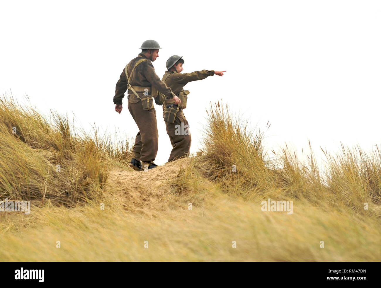 St Annes, Lancashire, Royaume-Uni. 13e Février 2019. Drame de guerre de la BBC World on Fire,est filmé sur St Annes beach,Lancashire. Le personnel de production, des acteurs et des véhicules ont été recueillies sur la vaste étendue de plage pour la réalisation de l'histoire épique se déroulant durant la seconde guerre mondiale. Deux soldats sur les dunes de sable au-dessus de la plage pendant le tournage.Kev Walsh/Alamy Live News Banque D'Images