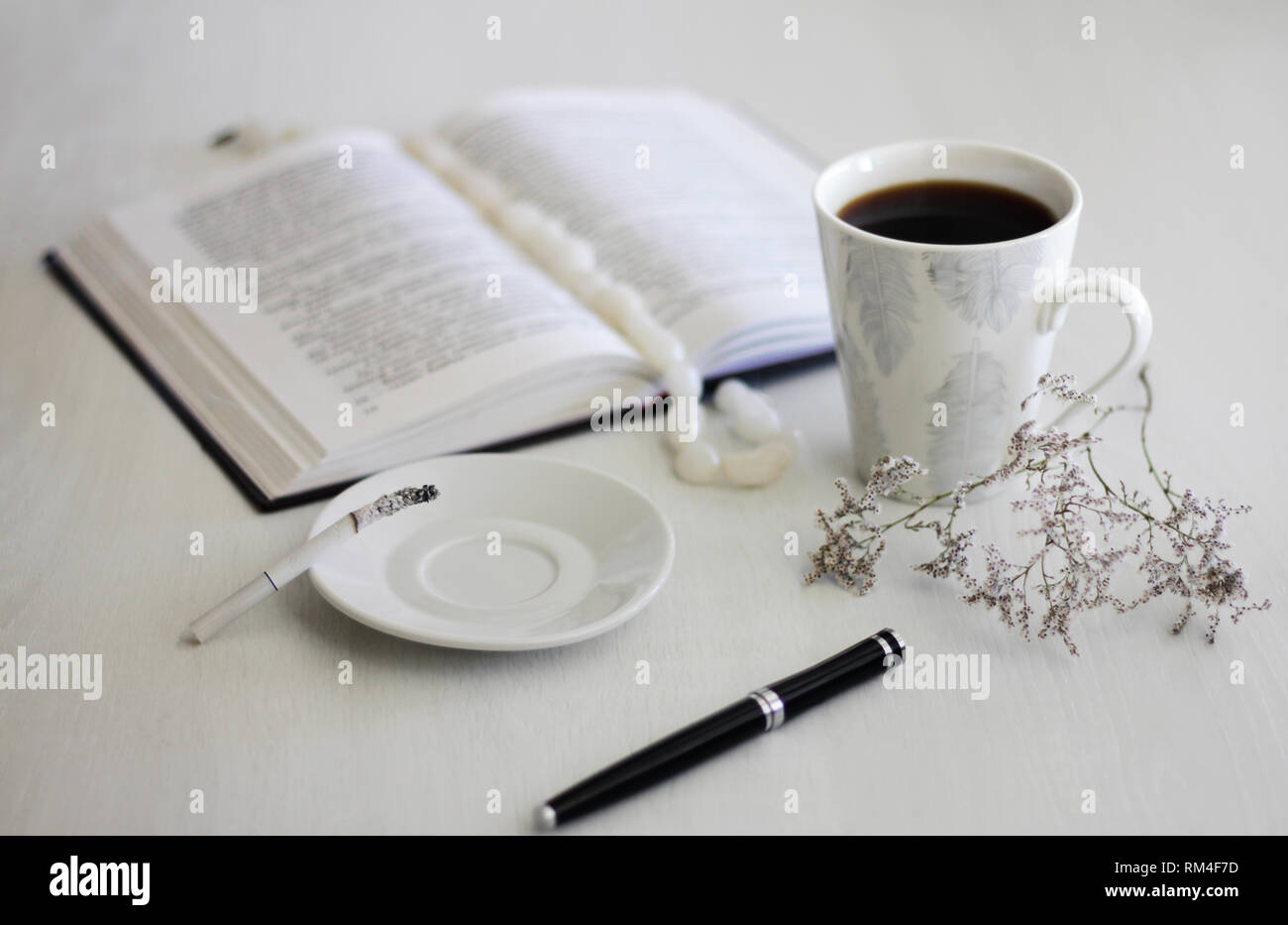 L'humeur du matin femme mains une tasse de café, un ordinateur portable et d'une cigarette sur une table en bois blanc Banque D'Images
