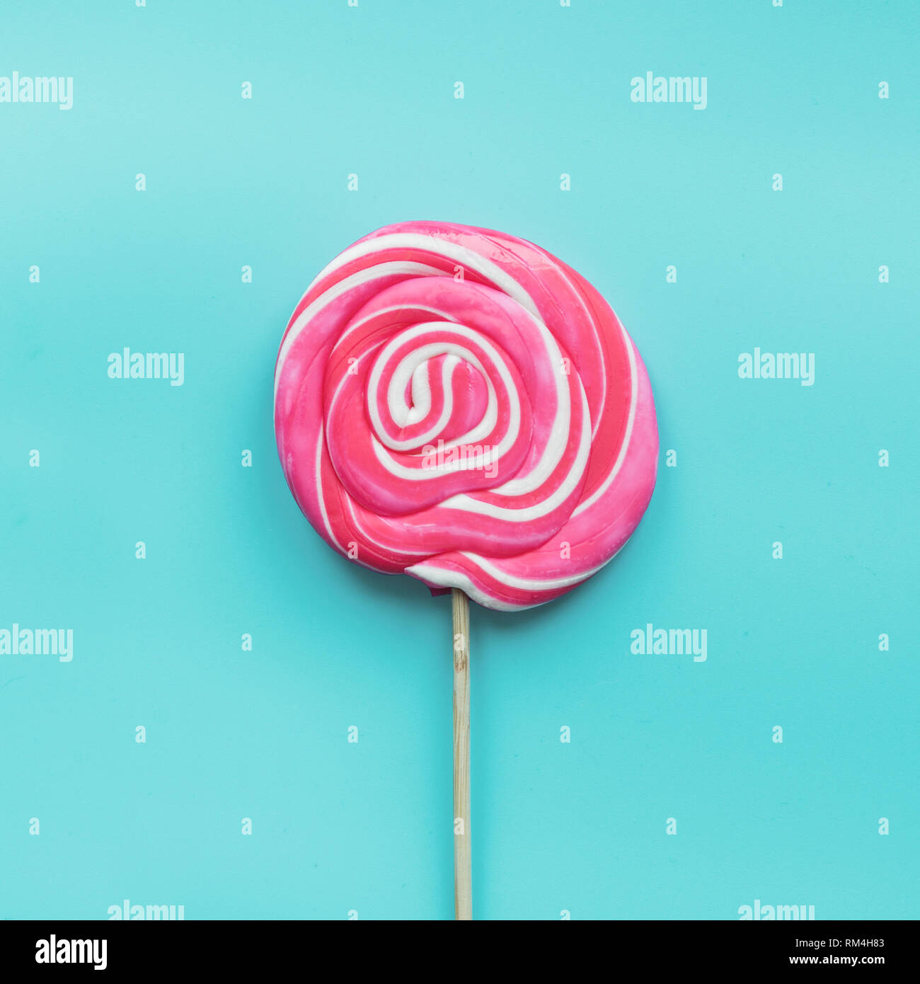 Bonbons sucettes tourbillon blanc et rose sur bleu pastel Photo Stock -  Alamy