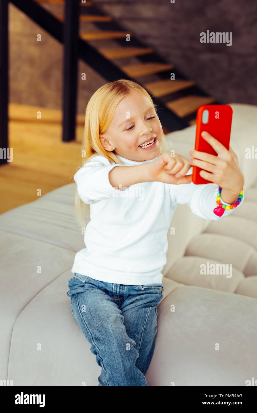 Amazing little female en utilisant son smartphone avec plaisir Banque D'Images