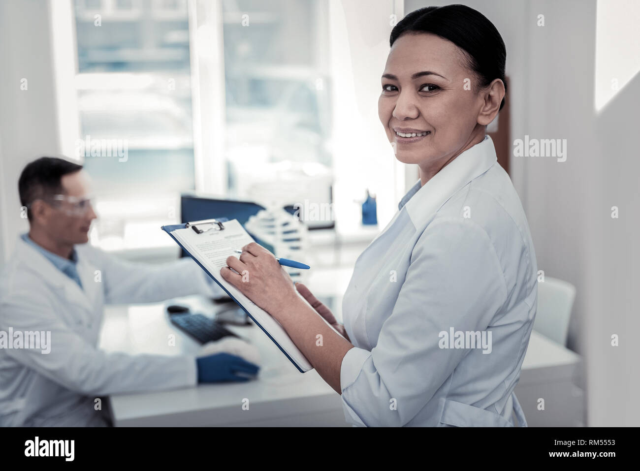 Assistant de laboratoire faisant remarques importantes dans le laboratoire Banque D'Images