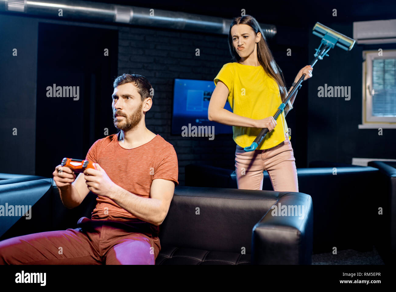 Jeune femme en colère contre son petit ami à jouer aux jeux vidéo avec console de jeux assis sur le canapé à la maison ou jouer club Banque D'Images