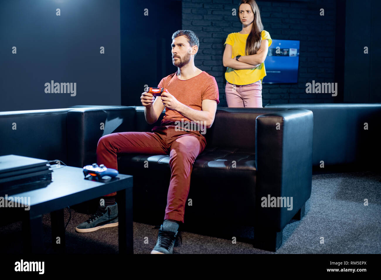 Jeune femme en colère contre son petit ami à jouer aux jeux vidéo avec console de jeux assis sur le canapé à la maison ou jouer club Banque D'Images
