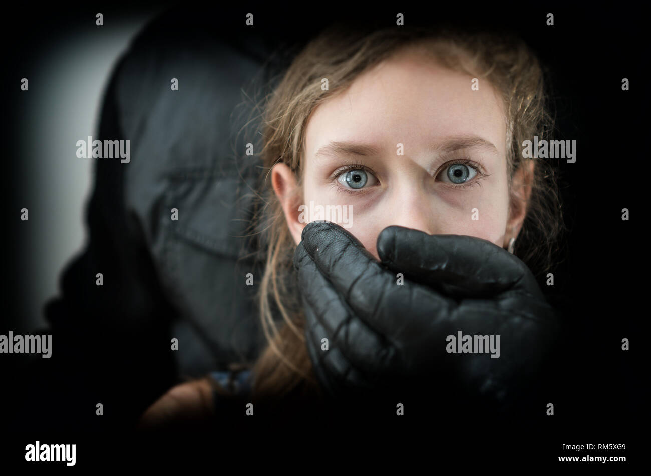 La main de l'homme couvrant la bouche de la jeune fille effrayée. Banque D'Images