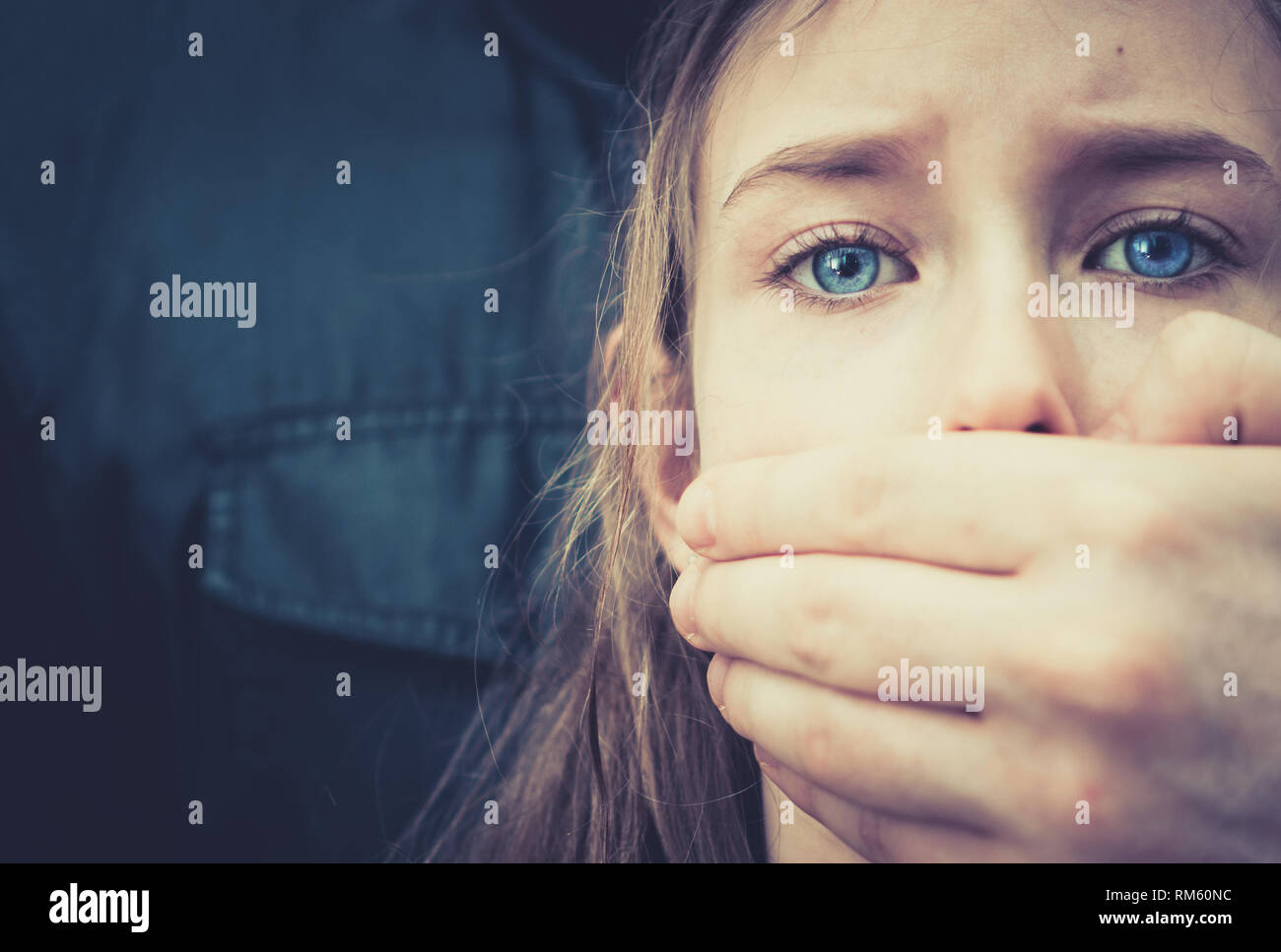 La main de l'homme couvrant la bouche de la jeune fille effrayée. Banque D'Images