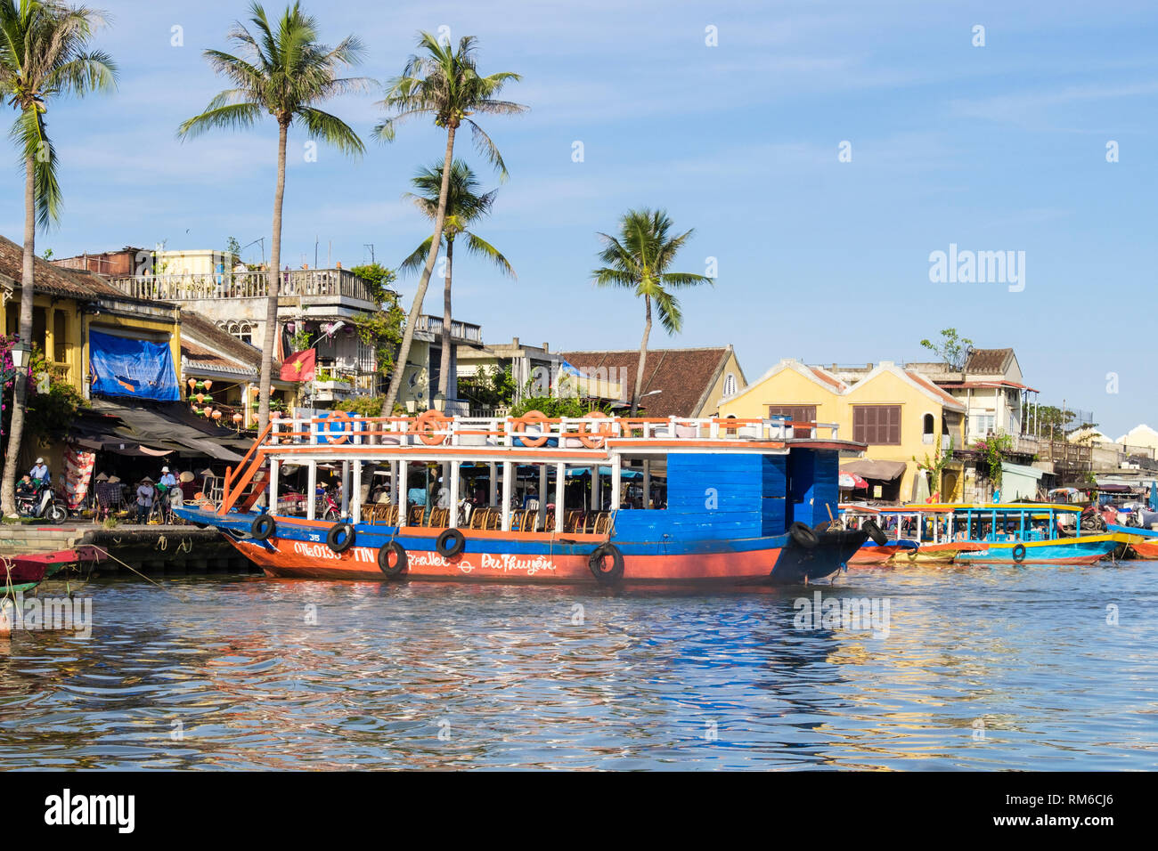 Vue sur l'eau à sampans touristiques traditionnels bateaux amarrés le long de la rivière Thu Bon dans le vieux quartier de la ville historique. Hoi An, Quang Nam Province, Vietnam Banque D'Images