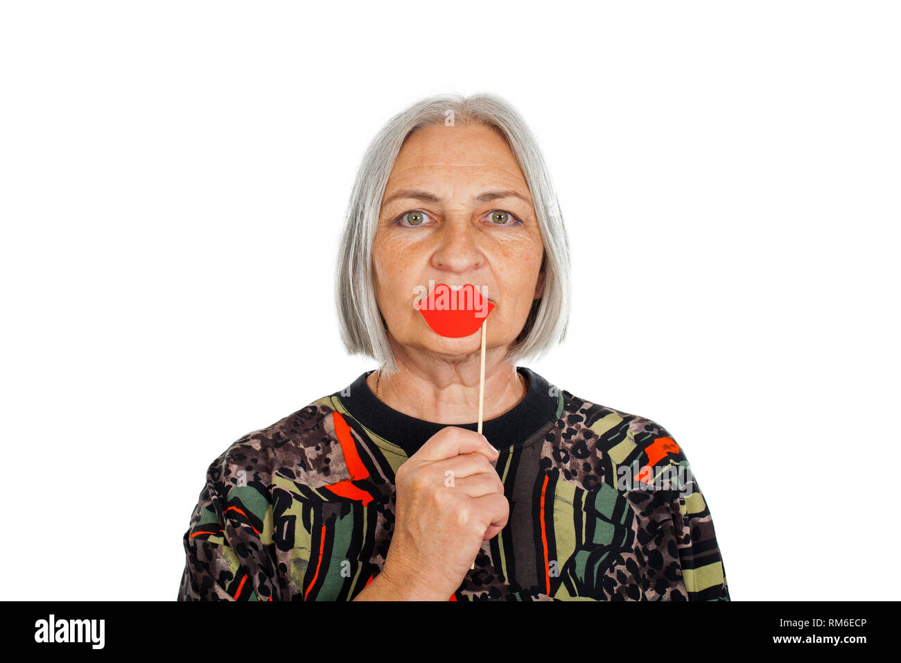 Senior woman holding red lèvres embrassant sur fond isolé. Accessoires Photo Booth Banque D'Images