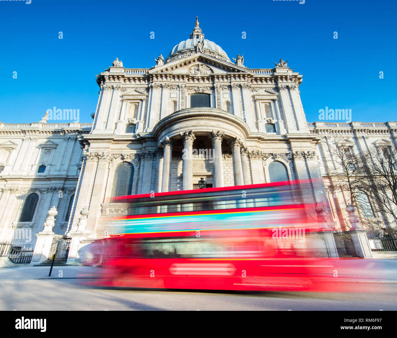 Un grand bus rouge en passant devant la Cathédrale St Paul à Londres. Banque D'Images
