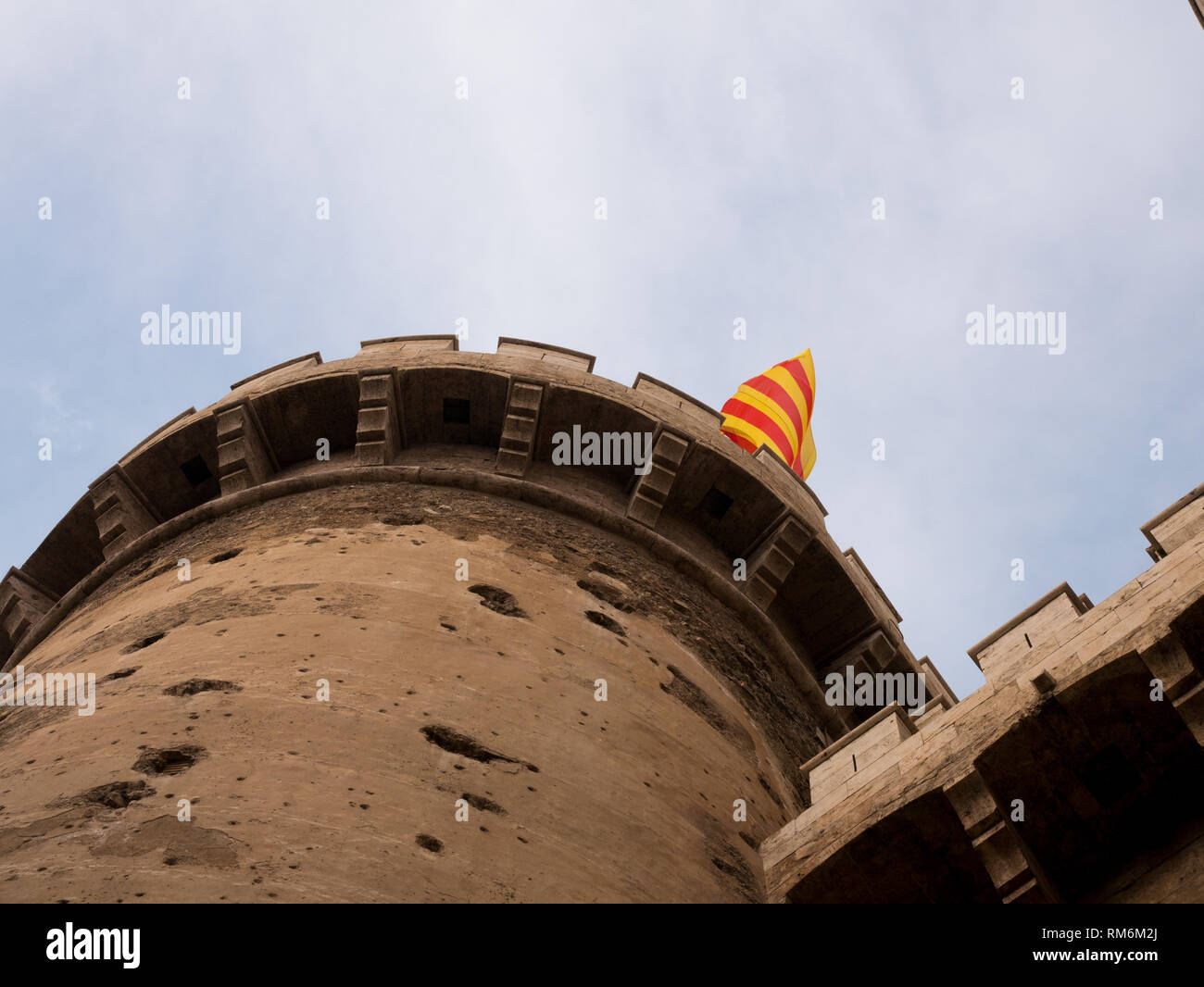 Brandir le drapeau espagnol sur les Torres de Quart, la porte du mur médiévale chrétienne de Valence Banque D'Images