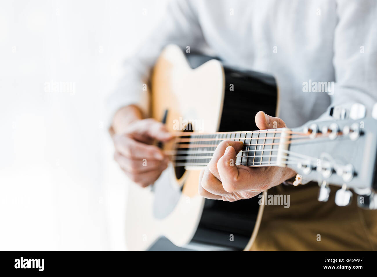 Portrait of senior man playing guitar at home Banque D'Images